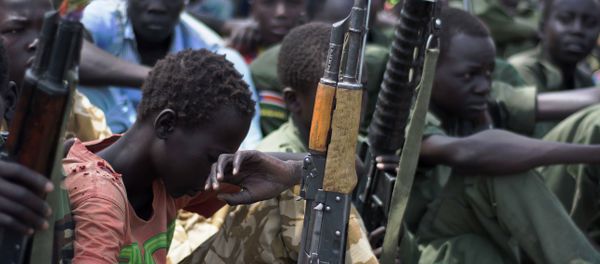 A file photo taken on February 10, 2015 shows young boys, child soldiers sitting on with their rifles - Sputnik International