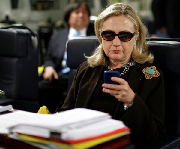 Former US Secretary of State Hillary Clinton checks her PDA upon her departure in a military C-17 plane from Malta bound for Tripoli, Libya, in this October 18, 2011, file photo - Sputnik International