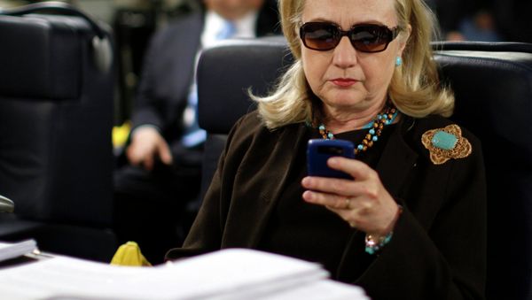 Former US Secretary of State Hillary Clinton checks her PDA upon her departure in a military C-17 plane from Malta bound for Tripoli, Libya, in this October 18, 2011, file photo - Sputnik International