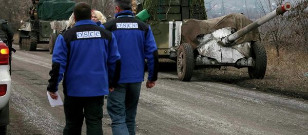 Members of Special Monitoring Mission of the Organization for Security and Cooperation (OSCE) to Ukraine walk along a convoy of Ukrainian armed forces in Paraskoviyvka, eastern Ukraine, February 26, 2015 - Sputnik International