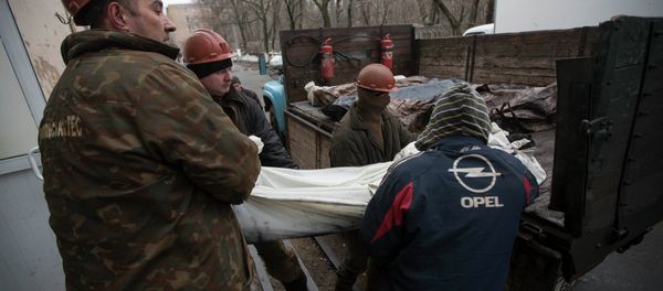 Miners carry a covered body of one of their co-workers killed by a blast at the Zasyadko coal mine into a morgue in Donetsk March 5, 2015 - Sputnik International
