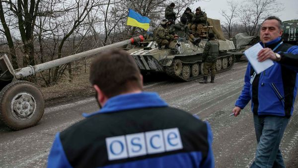 Members of Special Monitoring Mission of the Organization for Security and Cooperation (OSCE) to Ukraine walk along a convoy of Ukrainian armed forces in Paraskoviyvka, eastern Ukraine, February 26, 2015 - Sputnik International