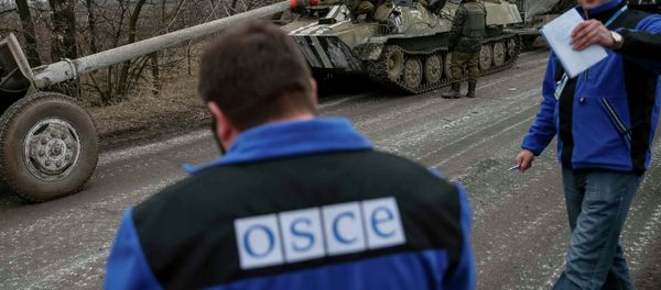 Members of Special Monitoring Mission of the Organization for Security and Cooperation (OSCE) to Ukraine walk along a convoy of Ukrainian armed forces in Paraskoviyvka, eastern Ukraine, February 26, 2015 - Sputnik International