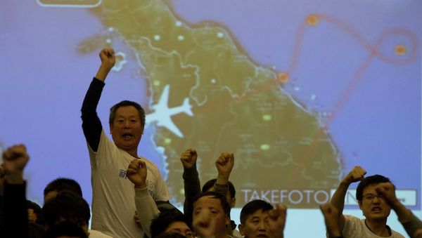 Relatives of Chinese passengers aboard the missing Malaysia Airlines, MH370, turn to journalists to shout their demands for answers after Malaysian government representatives left a briefing in Beijing, China - Sputnik International