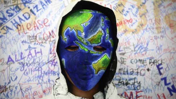 An unidentified woman wearing a mask depicting the flight of the missing Malaysia Airline, MH370, poses in front of the wall of hope at Kuala Lumpur International Airport in Sepang, Malaysia - Sputnik International
