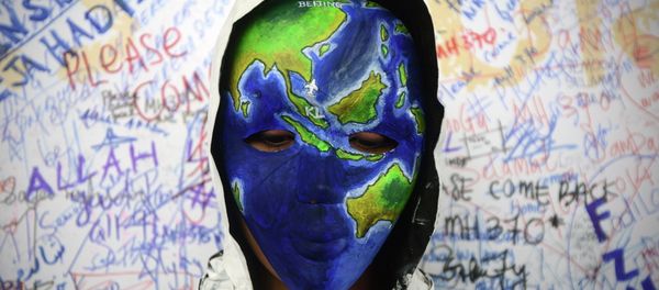 An unidentified woman wearing a mask depicting the flight of the missing Malaysia Airline, MH370, poses in front of the wall of hope at Kuala Lumpur International Airport in Sepang, Malaysia - Sputnik International