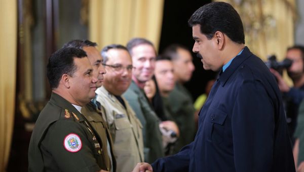 Venezuela's President Nicolas Maduro (R) greets Gustavo Gonzalez as he welcomes army members sanctioned by the U.S. during a national TV broadcast in Caracas in this March 9, 2015 picture provided by Miraflores Palace. - Sputnik International