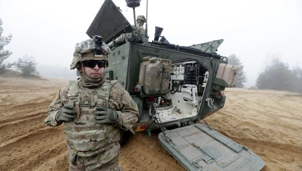 Soldiers of the U.S. Army's 2nd Cavalry Regiment, deployed in Latvia as part of the US Operation Atlantic Resolve, are pictured near their armored vehicle named Stryker during a joint military exercise in Adazi, Latvia - Sputnik International