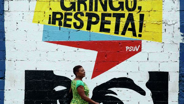 A woman walks past graffiti which reads Gringo, respect us! in Caracas March 10, 2015. President Nicolas Maduro was seeking special decree powers from Venezuela's parliament on Tuesday in response to new U.S. sanctions, drawing opposition protests of a power-grab - Sputnik International