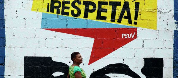A woman walks past graffiti which reads Gringo, respect us! in Caracas March 10, 2015. President Nicolas Maduro was seeking special decree powers from Venezuela's parliament on Tuesday in response to new U.S. sanctions, drawing opposition protests of a power-grab - Sputnik International