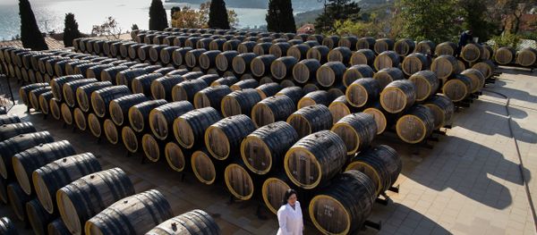In this photo taken on Tuesday, Oct. 28, 2014, Rameta Kushkhova walks by barrels of wine in the state-owned Massandra winery in Yalta, Crimea - Sputnik International