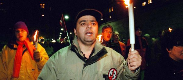 An unidentified protester carries his torch together with some 300 others in a march in Stockholm, Sweden - Sputnik International