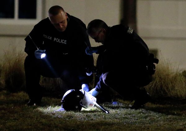 Police shine a light on a helmet as they investigate the scene where two police officers were shot outside the Ferguson Police Department Thursday, March 12, 2015, in Ferguson, Mo - Sputnik International