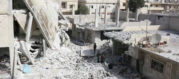 Men walk amidst the rubble of damaged buildings at a site hit on Tuesday by what activists said were airstrikes by forces loyal to Syria's President Bashar al-Assad in the rebel-controlled area of Deir al-Asafir town, near Damascus March 11, 2015 - Sputnik International