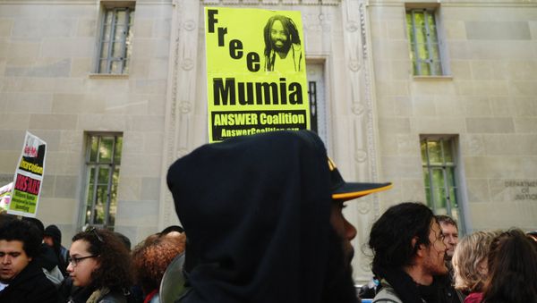 Protestors stand before an image of Mumia Abu-Jamal outside the US Department of Justice on April 24, 2012 in Washington - Sputnik International