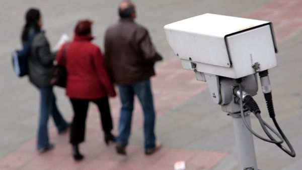 A police CCTV camera observes people walking in the Embankment area of central London - Sputnik International