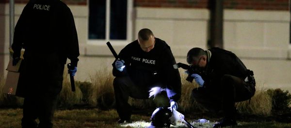 Police shine a light on and photograph a helmet as they investigate the scene where two police officers were shot outside the Ferguson Police Department Thursday, March 12, 2015, in Ferguson, Mo Police shine a light on and photograph a helmet as they investigate the scene where two police officers were shot outside the Ferguson Police Department Thursday, March 12, 2015, in Ferguson, Mo - Sputnik International