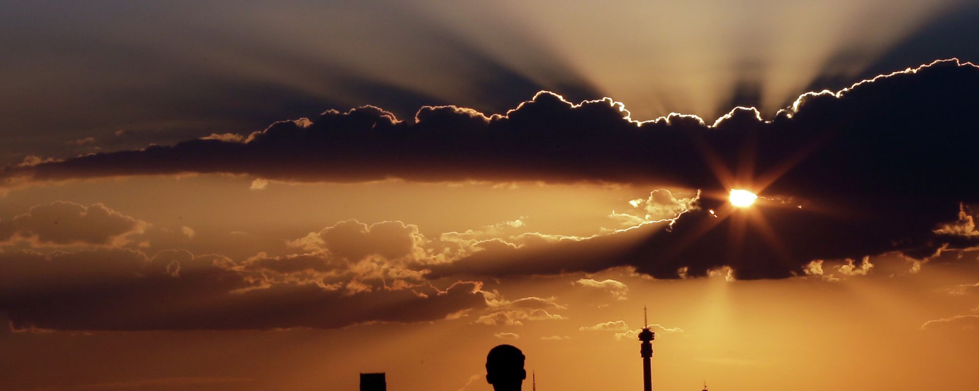 A man watches the sun set in as he overlooks the skyline in Johannesburg, South Africa. - Sputnik International, 1920, 16.12.2022