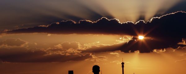 A man watches the sun set in as he overlooks the skyline in Johannesburg, South Africa A man watches the sun set in as he overlooks the skyline in Johannesburg, South Africa - Sputnik International