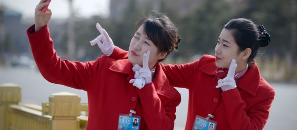 Chinese hostesses use a mobile phone to take a photo during the third session of the 12th National People's Congress outside the Great Hall of the People in Beijing Chinese hostesses use a mobile phone to take a photo during the third session of the 12th National People's Congress outside the Great Hall of the People in Beijing - Sputnik International