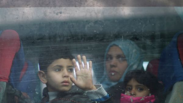 A Palestinian boy looks out a bus window as he waits with family to cross into Egypt, at the Rafah crossing between Egypt and the southern Gaza Strip - Sputnik International