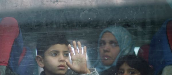 A Palestinian boy looks out a bus window as he waits with family to cross into Egypt, at the Rafah crossing between Egypt and the southern Gaza Strip - Sputnik International