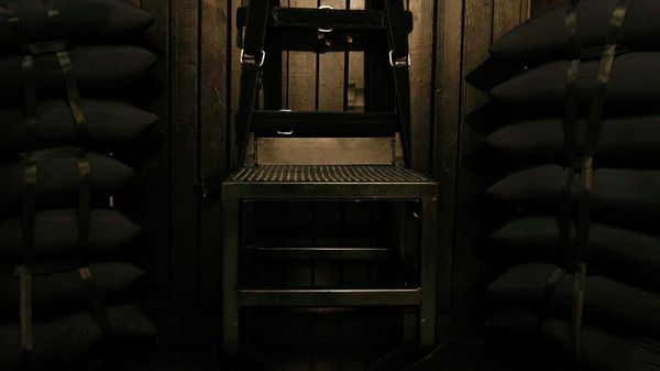 Bullet holes are visible in the wood panel behind the chair in the execution chamber at the Utah State Prison after Ronnie Lee Gardner was executed by firing squad - Sputnik International