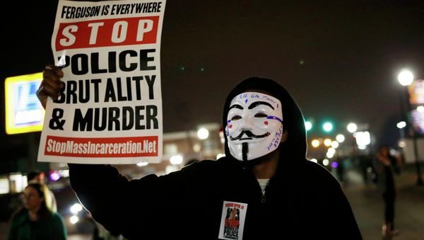 A protestor wearing a Guy Fawkes mask holds a sign as demonstrators march through the streets of Ferguson, Missouri, March 12, 2015 A protestor wearing a Guy Fawkes mask holds a sign as demonstrators march through the streets of Ferguson, Missouri, March 12, 2015 - Sputnik International