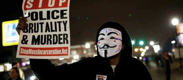 A protestor wearing a Guy Fawkes mask holds a sign as demonstrators march through the streets of Ferguson, Missouri, March 12, 2015 A protestor wearing a Guy Fawkes mask holds a sign as demonstrators march through the streets of Ferguson, Missouri, March 12, 2015 - Sputnik International