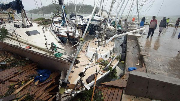 Local residents look at damaged boats against a jetty in Port Vila, the capital city of the Pacific island nation of Vanuatu March 14, 2015 - Sputnik International