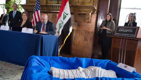 Assistant Secretary of Homeland Security for Immigration and Customs Enforcement Sarah Saldaña (seated, L) and Iraqi Ambassador to the US Lukman Faily sign documents behind a sculpture of the head of Assyrian King Sargon II during a ceremony to repatriate more than 60 Iraqi artifacts which had been smuggled into the US at the Iraqi consulate in Washington, DC, on March 16, 2015. Assistant Secretary of Homeland Security for Immigration and Customs Enforcement Sarah Saldaña (seated, L) and Iraqi Ambassador to the US Lukman Faily sign documents behind a sculpture of the head of Assyrian King Sargon II during a ceremony to repatriate more than 60 Iraqi artifacts which had been smuggled into the US at the Iraqi consulate in Washington, DC, on March 16, 2015. - Sputnik International