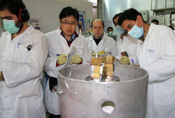 Unidentified International Atomic Energy Agency (IAEA) inspectors (2nd-3rd L) and Iranian technicians disconnect the connections between the twin cascades for 20 percent uranium production at nuclear power plant of Natanz, some 300 kilometres south of Tehran. File photo  - Sputnik International