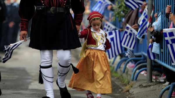 A girl dressed in a traditional costume holds the hand of a man in traditional military uniform during a parade, in the northern port city of Thessaloniki A girl dressed in a traditional costume holds the hand of a man in traditional military uniform during a parade, in the northern port city of Thessaloniki - Sputnik International