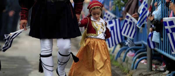 A girl dressed in a traditional costume holds the hand of a man in traditional military uniform during a parade, in the northern port city of Thessaloniki A girl dressed in a traditional costume holds the hand of a man in traditional military uniform during a parade, in the northern port city of Thessaloniki - Sputnik International