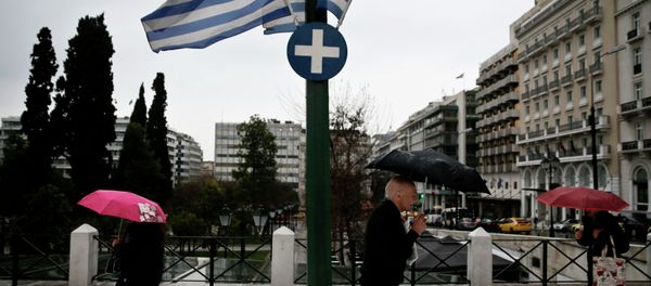 People holding umbrellas make their way next to fluttering Greek national flags on the main Constitution (Syntagma) square during heavy rainfall in Athens People holding umbrellas make their way next to fluttering Greek national flags on the main Constitution (Syntagma) square during heavy rainfall in Athens - Sputnik International
