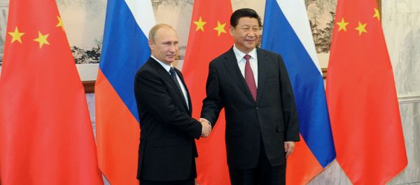 Russian President Vladimir Putin, left, shakes hands with Chinese President Xi Jinping prior to the Asia-Pacific Economic Cooperation (APEC) forum in Beijing - Sputnik International