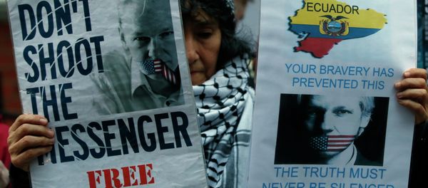 A demonstrator holds up placards as she protests outside the Ecuadorian Embassy in London. A demonstrator holds up placards as she protests outside the Ecuadorian Embassy in London. - Sputnik International