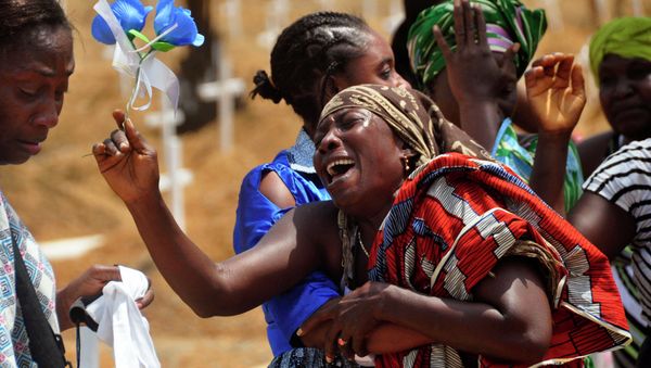 Relatives weep as they bury a loved one suspected of dying from the Ebola virus at a new graveyard on the outskirts of Monrovia, Liberia, March 11, 2015 - Sputnik International