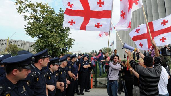 Supporters of the opposition party of former Georgian President Mikhail Saakashvili United National Movement wave flags of Georgia during a protest outside the party's headquarters in Tbilisi on October 15, 2014 - Sputnik International