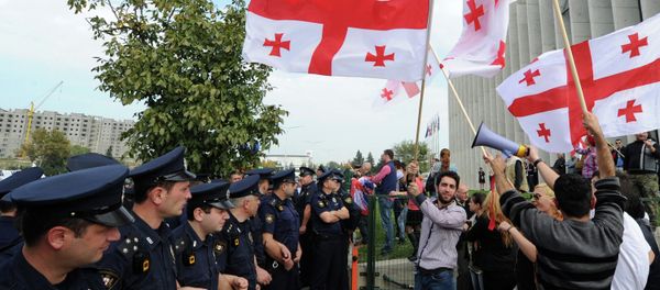 Supporters of the opposition party of former Georgian President Mikhail Saakashvili United National Movement wave flags of Georgia during a protest outside the party's headquarters in Tbilisi on October 15, 2014 - Sputnik International
