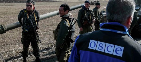 A member of Special Monitoring Mission of the Organization for Security and Cooperation (OSCE) to Ukraine walks along a convoy of Ukrainian armed forces in Blagodatne, eastern Ukraine, February 27, 2015 A member of Special Monitoring Mission of the Organization for Security and Cooperation (OSCE) to Ukraine walks along a convoy of Ukrainian armed forces in Blagodatne, eastern Ukraine, February 27, 2015 - Sputnik International