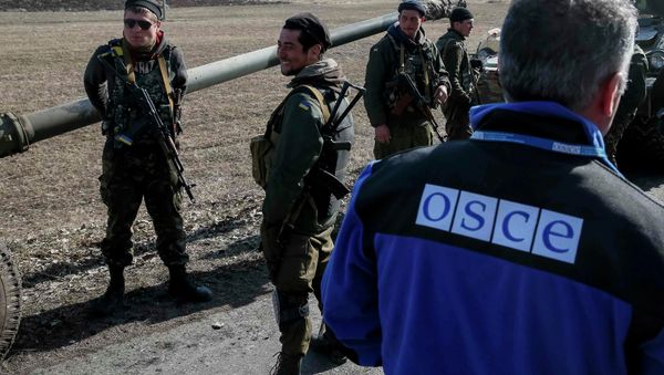 A member of Special Monitoring Mission of the Organization for Security and Cooperation (OSCE) to Ukraine walks along a convoy of Ukrainian armed forces in Blagodatne, eastern Ukraine, February 27, 2015 A member of Special Monitoring Mission of the Organization for Security and Cooperation (OSCE) to Ukraine walks along a convoy of Ukrainian armed forces in Blagodatne, eastern Ukraine, February 27, 2015 - Sputnik International