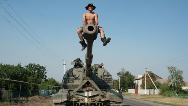 Ukrainian soldier sits atop of a self-propelled gun as an army column of military vehicles prepares to roll to a frontline near Illovaisk, Donetsk region, eastern Ukraine - Sputnik International