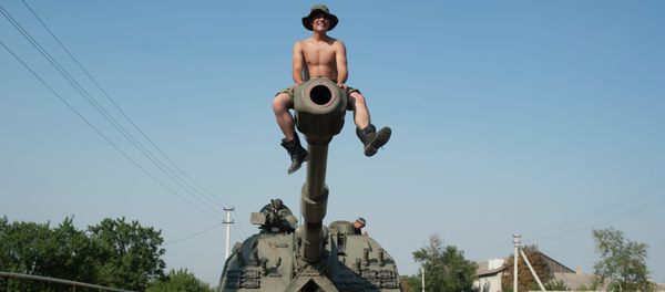 Ukrainian soldier sits atop of a self-propelled gun as an army column of military vehicles prepares to roll to a frontline near Illovaisk, Donetsk region, eastern Ukraine - Sputnik International