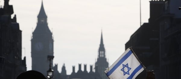 A demonstrator holds aloft an Israeli flag during a rally in Trafalgar Square in London A demonstrator holds aloft an Israeli flag during a rally in Trafalgar Square in London - Sputnik International