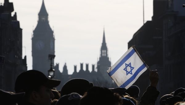 A demonstrator holds aloft an Israeli flag during a rally in Trafalgar Square in London A demonstrator holds aloft an Israeli flag during a rally in Trafalgar Square in London - Sputnik International