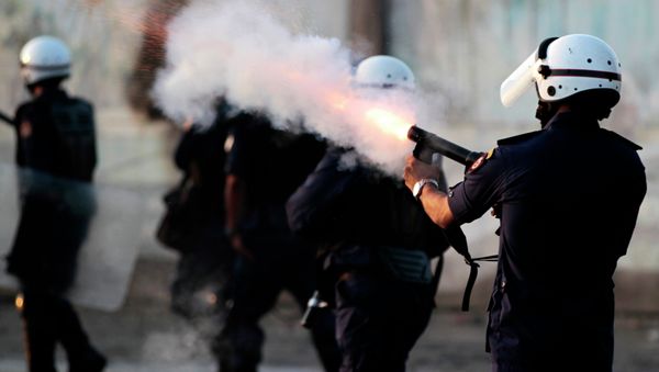 Riot police fire tear gas as they chase Bahraini anti-government protesters throwing stones and petrol bombs on the outskirts of the capital of Manama, Bahrain - Sputnik International