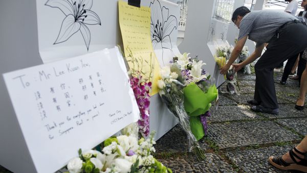 People lay flowers, as they mourn the passing of former prime minister Lee Kuan Yew, outside the Istana in Singapore, March 23, 2015 - Sputnik International