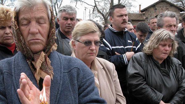 A Serbian woman lights a candle as she attends a memorial service in the monastery of Gracanica, some five kilometers East of Pristina, 24 March 2004  - Sputnik International