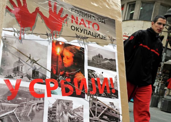 A man walks past a poster with the reading “Ten years of NATO occupation of Serbia”, and displaying images from 1999 NATO air campaign against Serbia and Montenegro, in Belgrade on March 23, 2009.  - Sputnik International